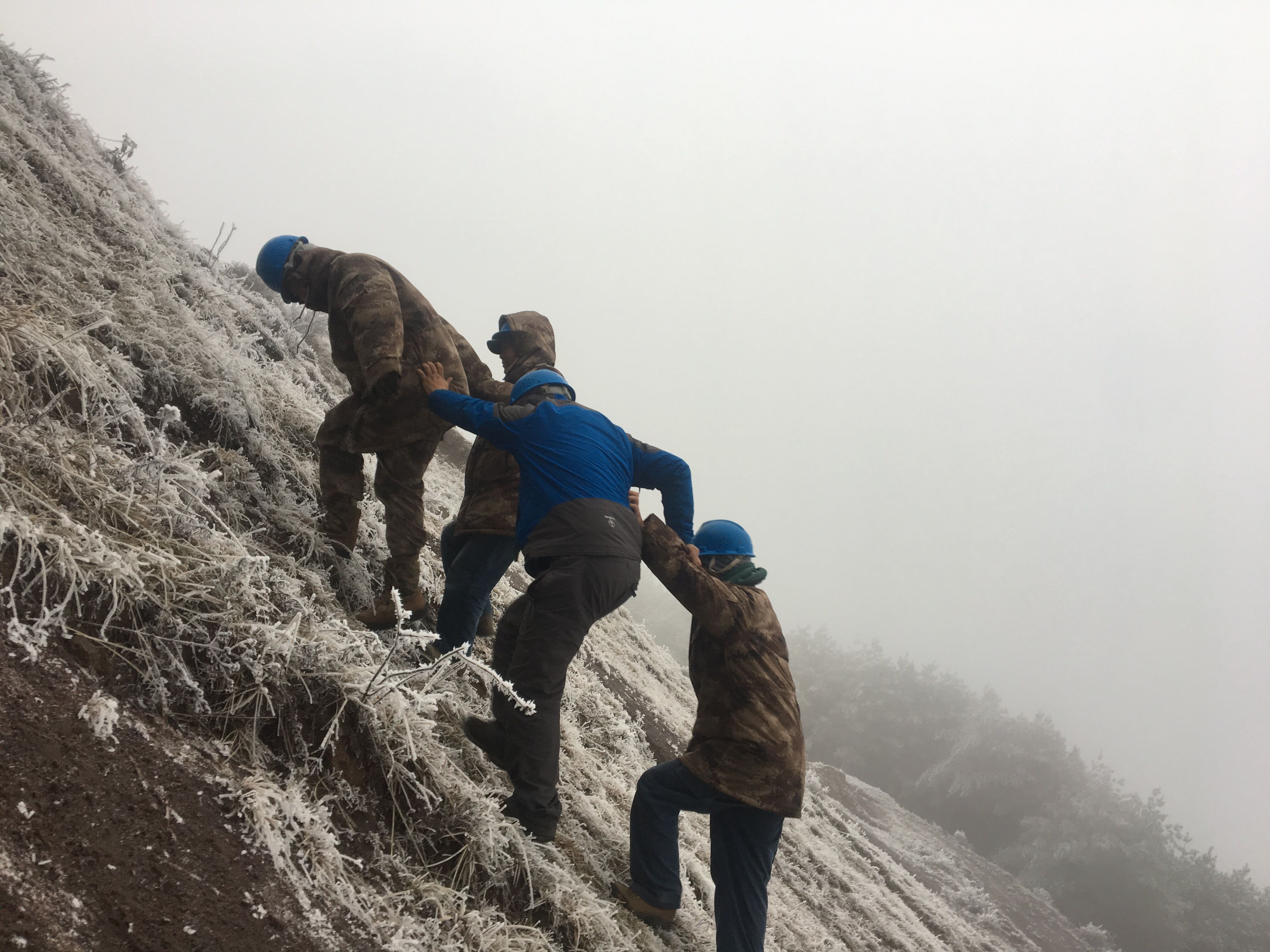 互相攙扶，勇登高峰。（李健攝）