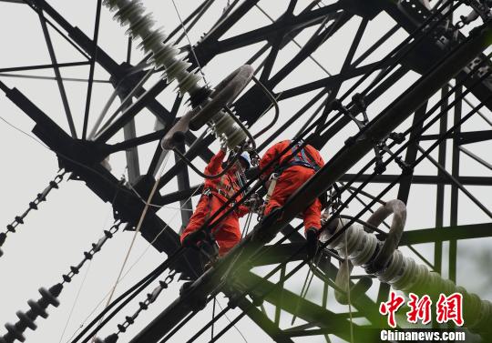 圖為電力工人在70多米高空作業(yè)，為特高壓復(fù)奉線重慶段進(jìn)行八年來首次大修?！≈芤?攝